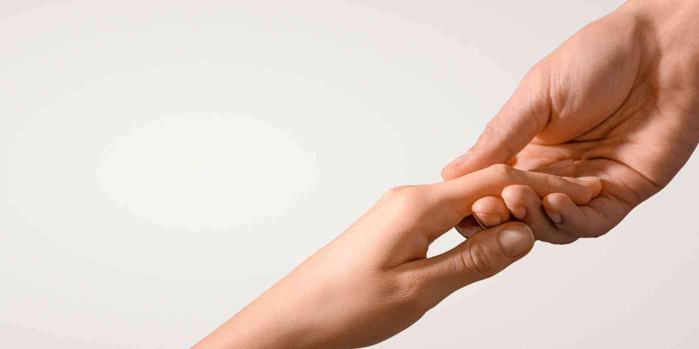 Depression therapy banner depicted by hand reaching up being held by hand reaching down - a helping hand