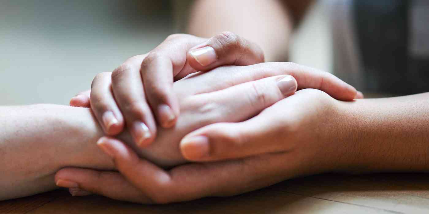 Photo of a pair of hands encircling a single hand depicting the anxiety therapy services offered at wave counselling and wellness in st john's nl.