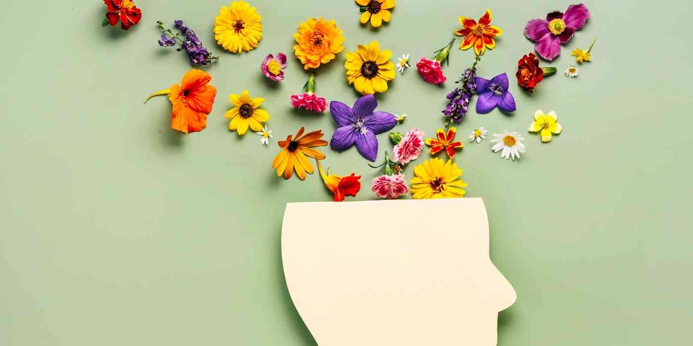 Image of flowers cascading out of a head shaped wooden vase, depicting the concept of anger management and anger therapy counselling at wave counselling and wellness in st. John's nl.