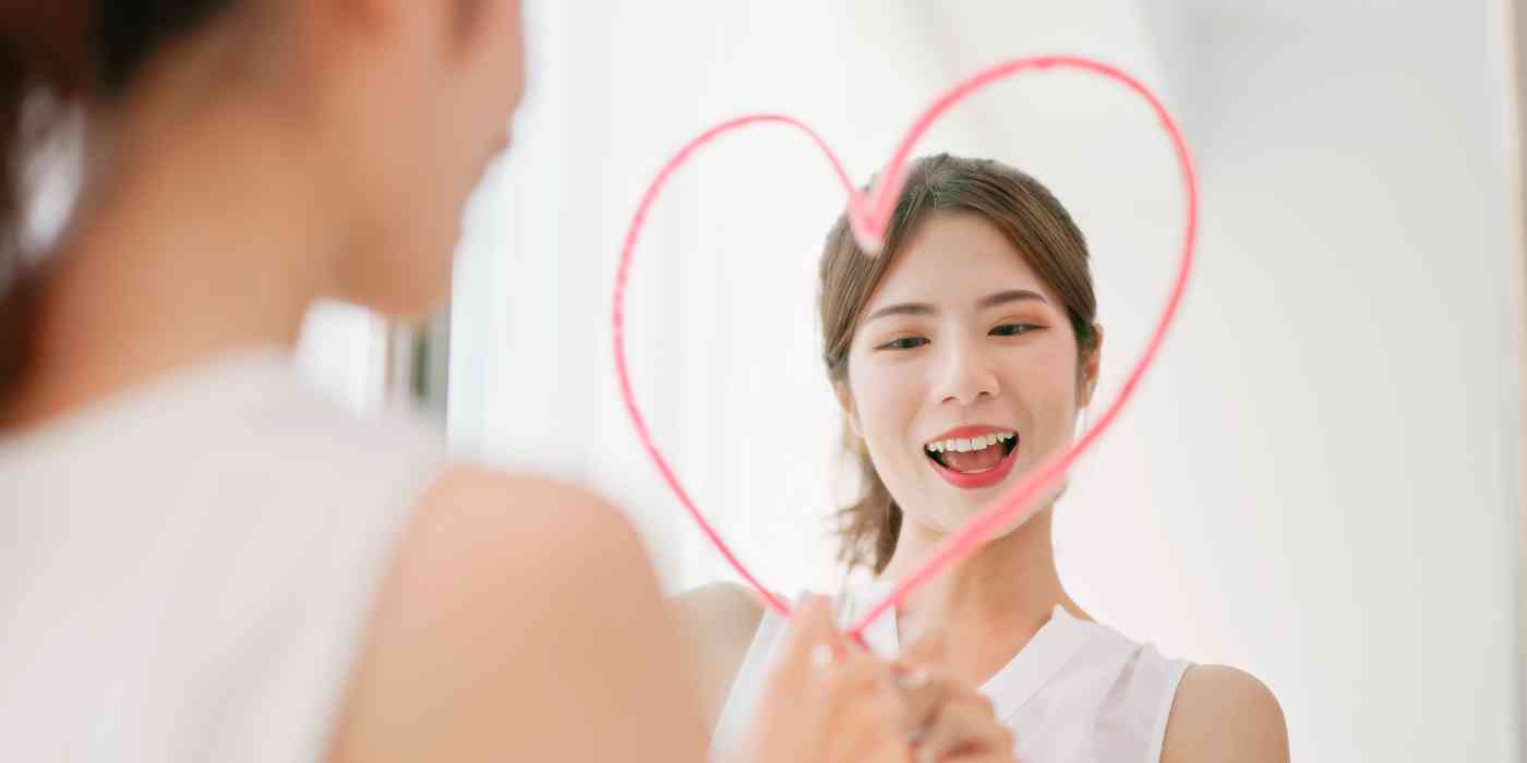 Concept image for bulimia therapy - female draws heart on mirror