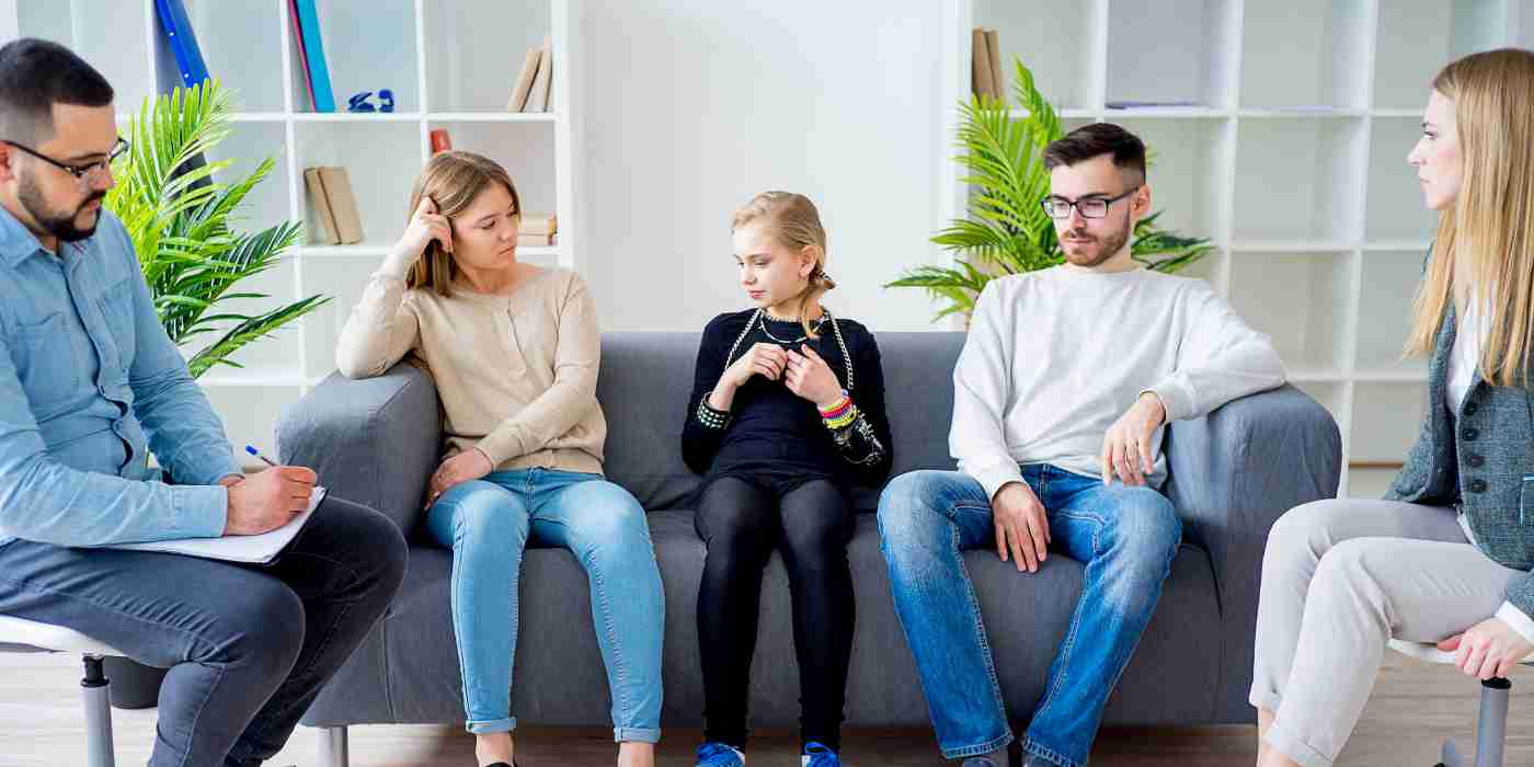 Banner for family-based therapy showing a family and a therapist in a room together.